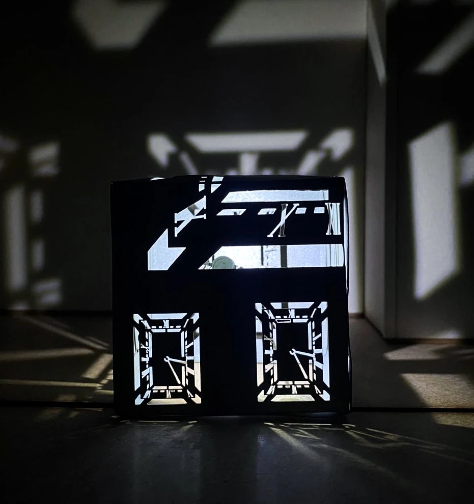 Maquette de la structure d’affichage : cadrans, chiffres romains et aiguilles découpés, projetés dans toute la pièce.
