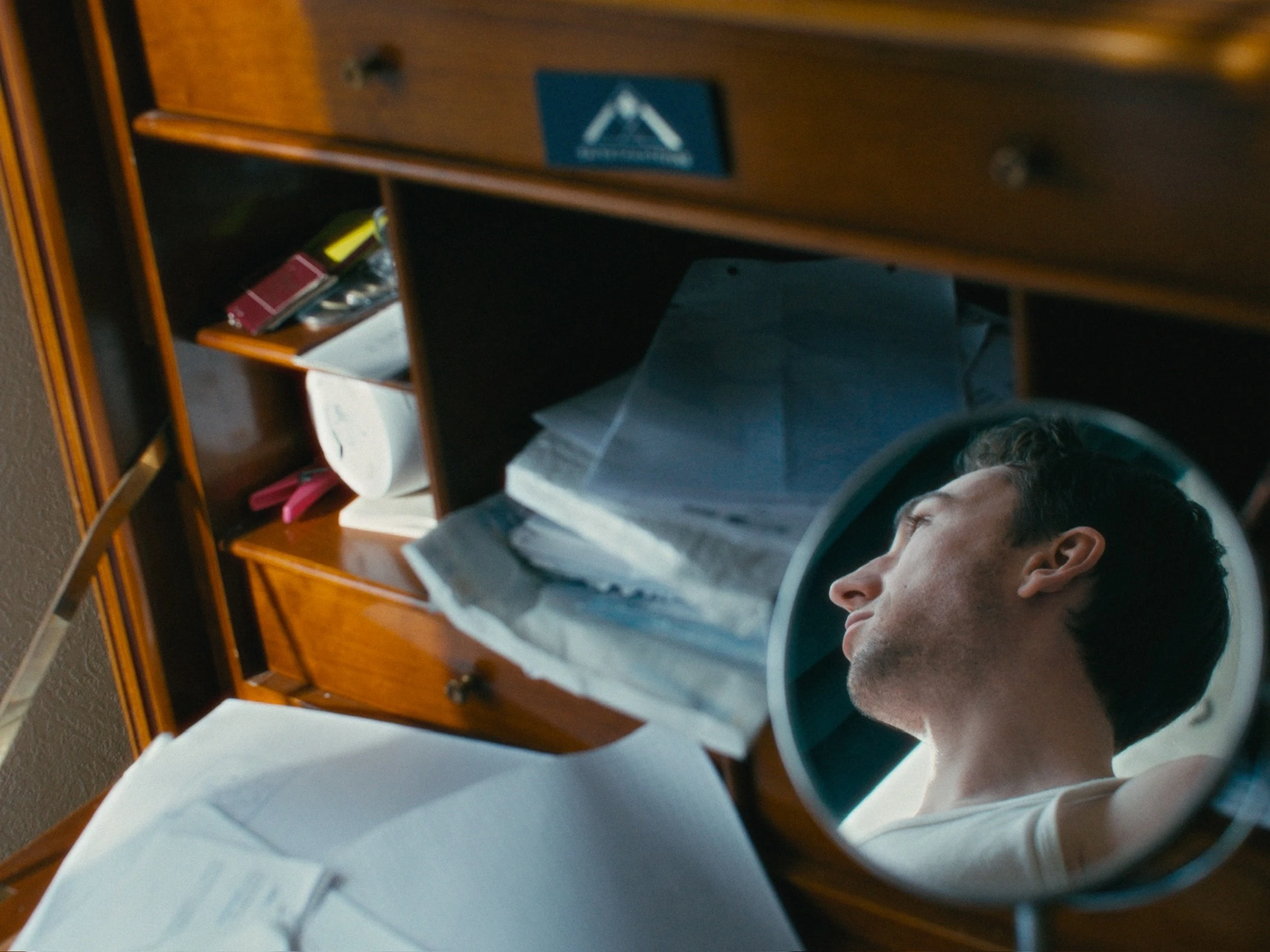 Photogramme du film — détail d'une commode ouverte, miroir rond.
