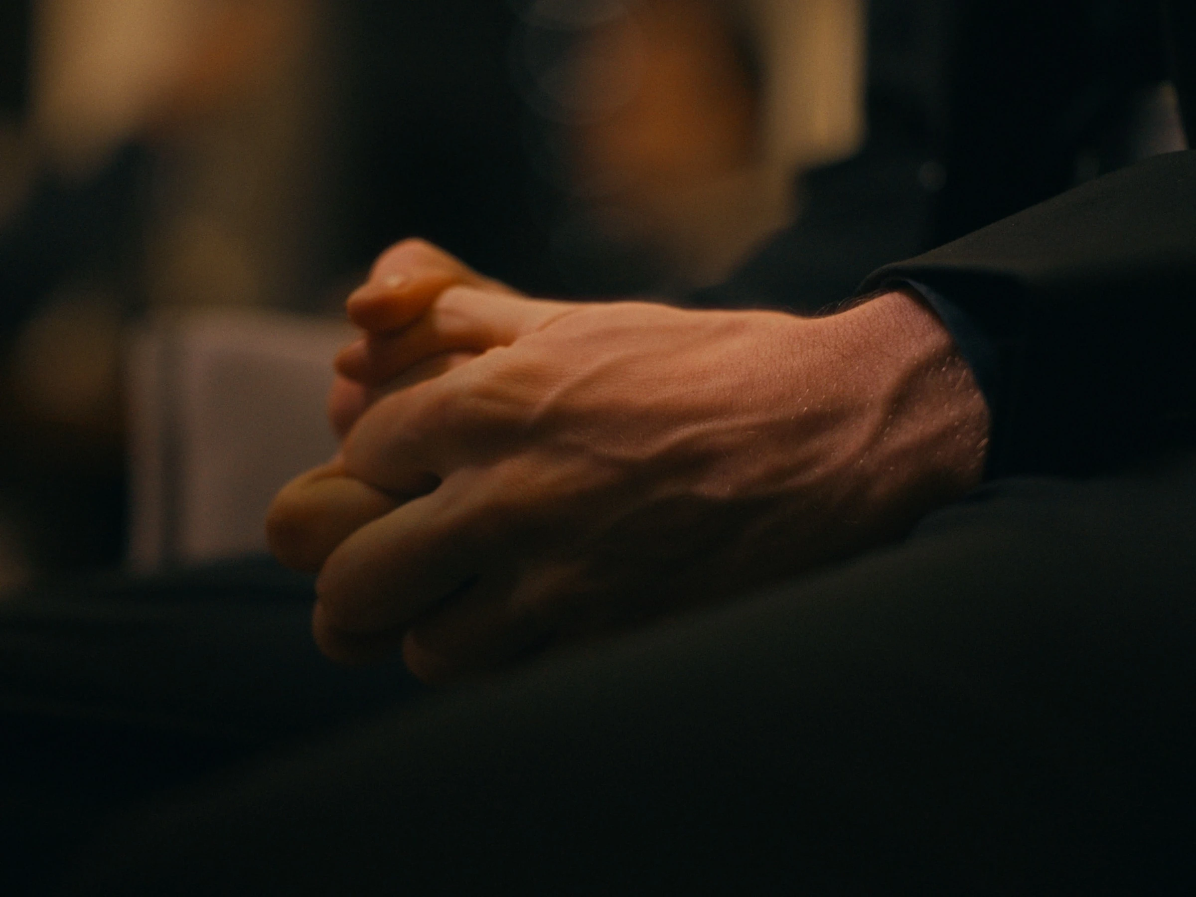 Photogramme du film — gros plan sur des mains, lumière chaude.